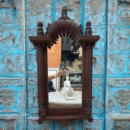 A large jharokha mirror frame featuring a big vintage mirror with intricate wood carvings, perfect for adding antique charm to living room or hallway decor.