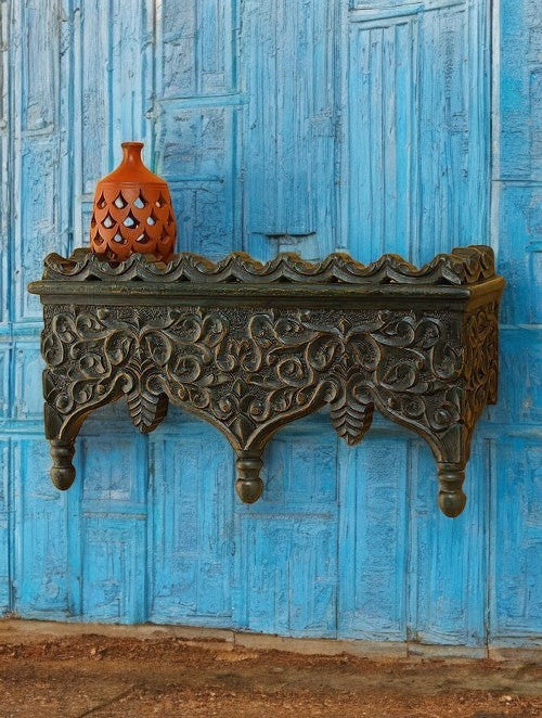 Handcrafted vintage temple-style wooden wall shelf with intricate carvings, adding a traditional touch to your home decor. Perfect for use as a pooja shelf, this antique-style piece combines functional storage with artistic beauty, ideal for living rooms or entryways.